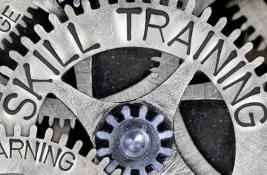 Macro photo of tooth wheel mechanism with skill training, education, learning, ability, knowledge and competence words imprinted on metal surface