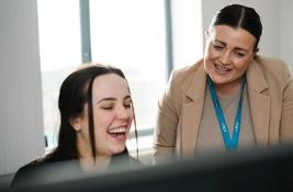 Two children's social workers looking happy while working