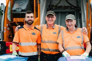 Refuse collectors in front of vehicle