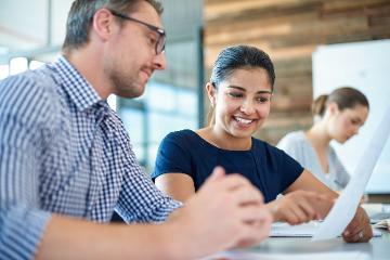 Three people at a desk looking at notes