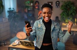 Woman celebrating holding mobile phone in hand