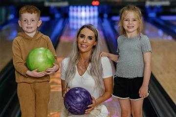 Woman with two children at bowling alley