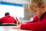 Primary school pupil working at a table